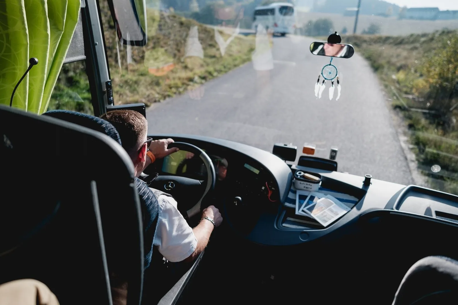 Blick vom Fahrerplatz eines Duschlbauer-Reisebusses durch die Frontscheibe auf eine Landstraße