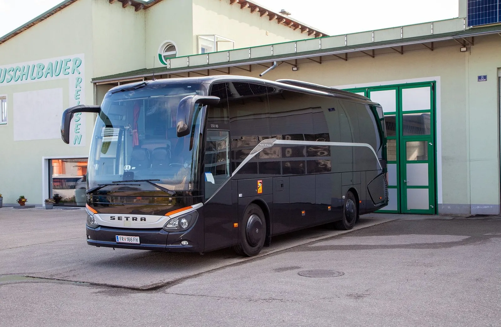 Kleiner Reisebus Setra 511 HD vor dem Gebäude mit Schriftzug Duschlbauer