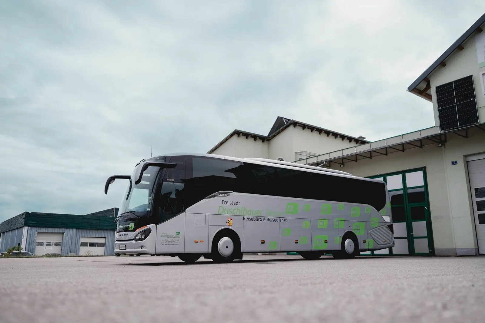 Reisebus Setra 515 HD vor der Halle mit Solarpaneelen