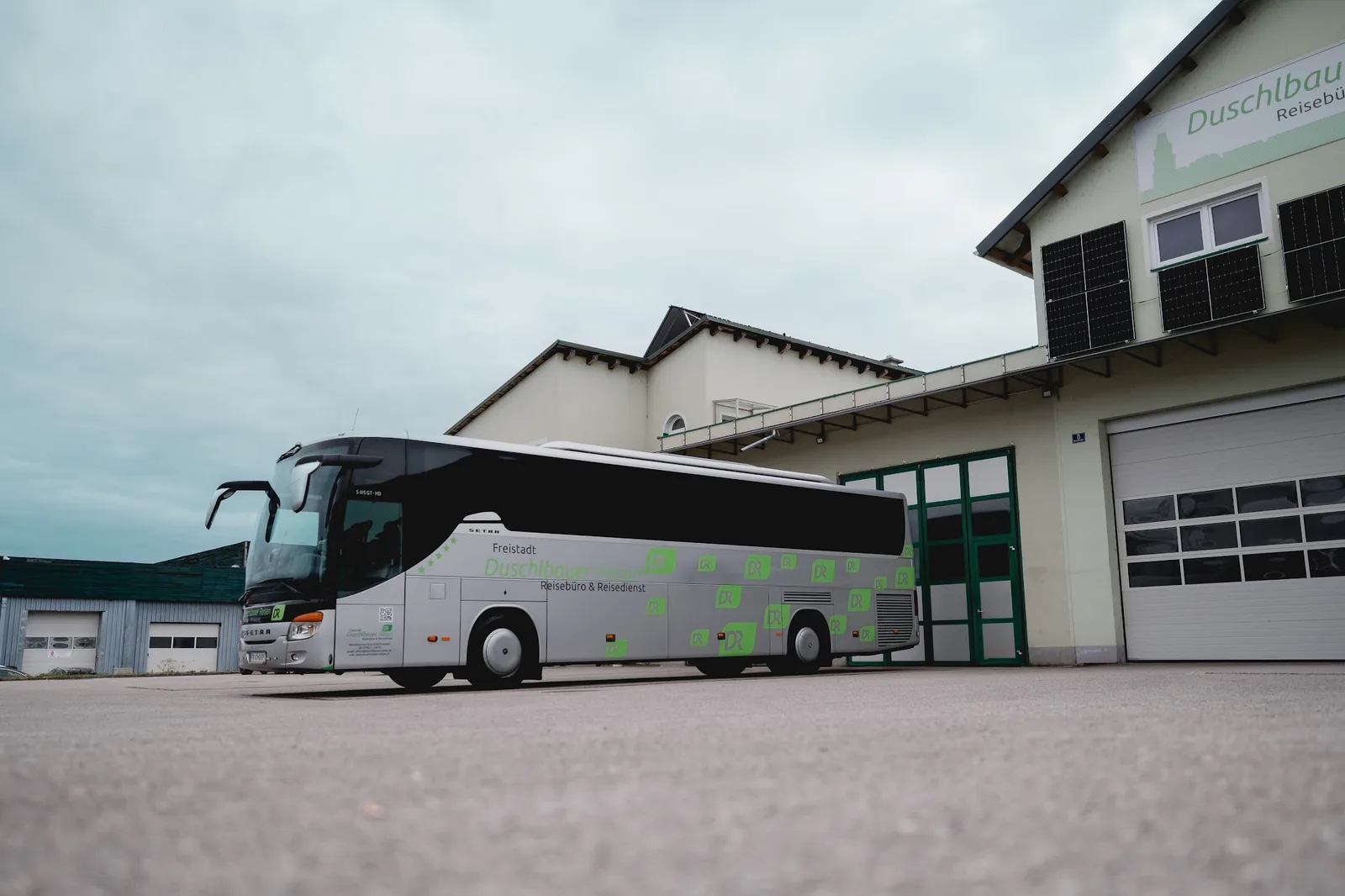 Reisebus Setra 415 GT-HD in Duschlbauer-Lackierung vor der Halle mit der Hausnummer 8